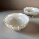 Ceramic bowls with stripes on beige surface.