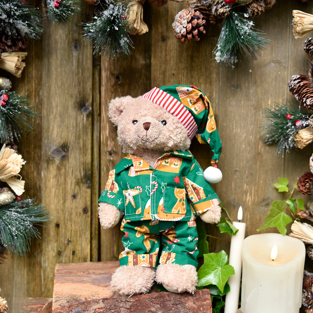 Teddy bear wearing gingerbread print green pyjamas.