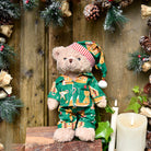 Teddy bear wearing gingerbread print green pyjamas.