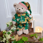 Teddy bear wearing gingerbread print green pyjamas.