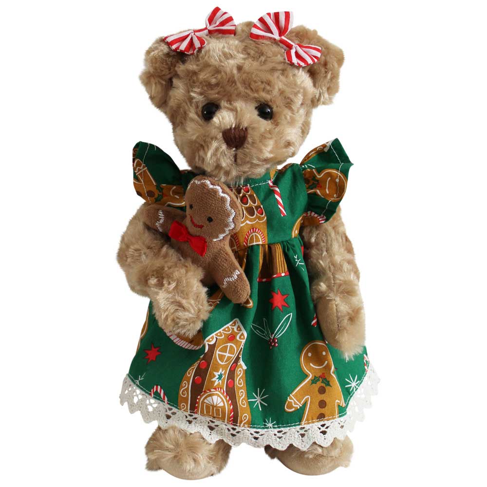 Super soft and cuddly teddy bear wearing a green dress with gingerbread design on a white background