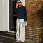 woman wearing navy jacket standing outside a door