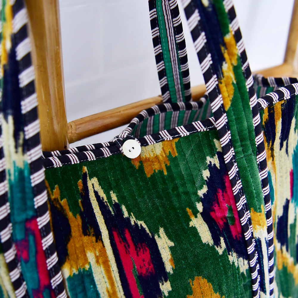 Detail of velvet ikat shopping bag showing mother of pearl button lifestyle
