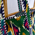 Detail of velvet ikat shopping bag showing mother of pearl button lifestyle
