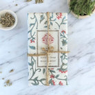 Bar of soap wrapped in floral paper and jute string.