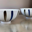 White ceramic bowl with grey and white stripes.