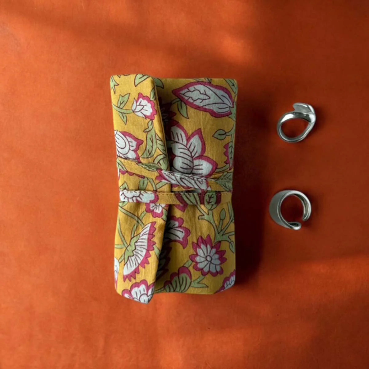 Yellow floral fabric jewellery roll.