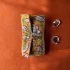 Yellow floral fabric jewellery roll.