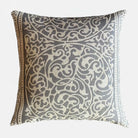 Decorative pillow with intricate fretwork pattern on a light gray background.