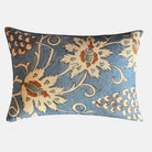 Decorative throw cushion with stone and rust coloured floral pattern on a blue background.