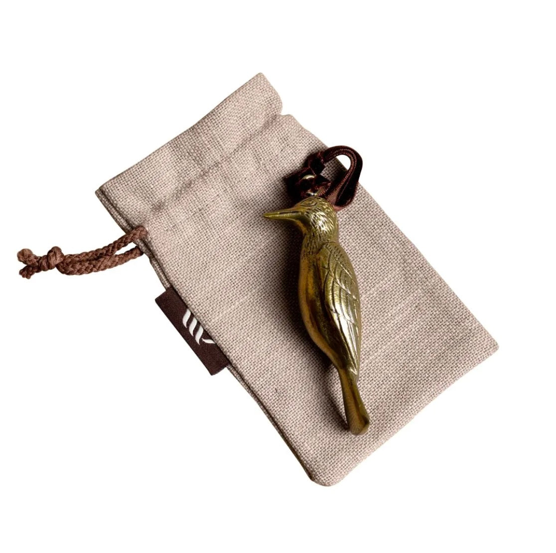Brass woodpecker-shaped hanging ornament on linen gift bag.